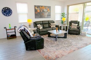 A living room with a sofa, armchair, coffee table, and a painting on the wall. - Star Light, Estrella Mountain Ranch (Goodyear)