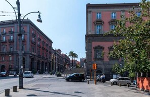 A street view with buildings, a traffic light, and a pedestrian crossing. - Luchino's Den (Napoli)