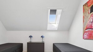 A room with two dark-colored sofas, a small dark-colored cabinet, and a skylight. - 4 Star Holiday Home in Allinge (Allinge)