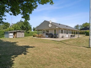 A single-story house with a covered patio, a barbecue grill, and a satellite dish. - 5 Star Holiday Home in Brenderup Fyn (Middelfart)