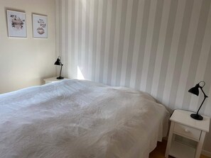 A bedroom with a bed, two bedside tables, and two wall-mounted lamps. - 5 Star Holiday Home in Nykobing Sj (Nykobing Sjaelland)