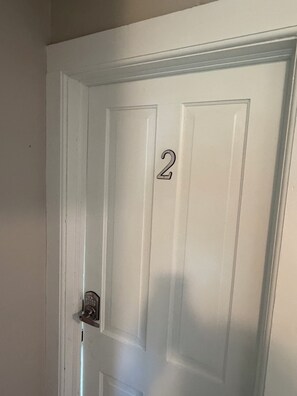 A white door with the number 2 on it, a door handle, and a keyhole. - Cozy Home close to Notre Dame & Downtown Southbend (South Bend)