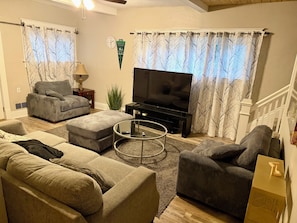 A living room with a sofa set, a coffee table, a television, and curtains. - Cozy Home close to Notre Dame & Downtown Southbend (South Bend)
