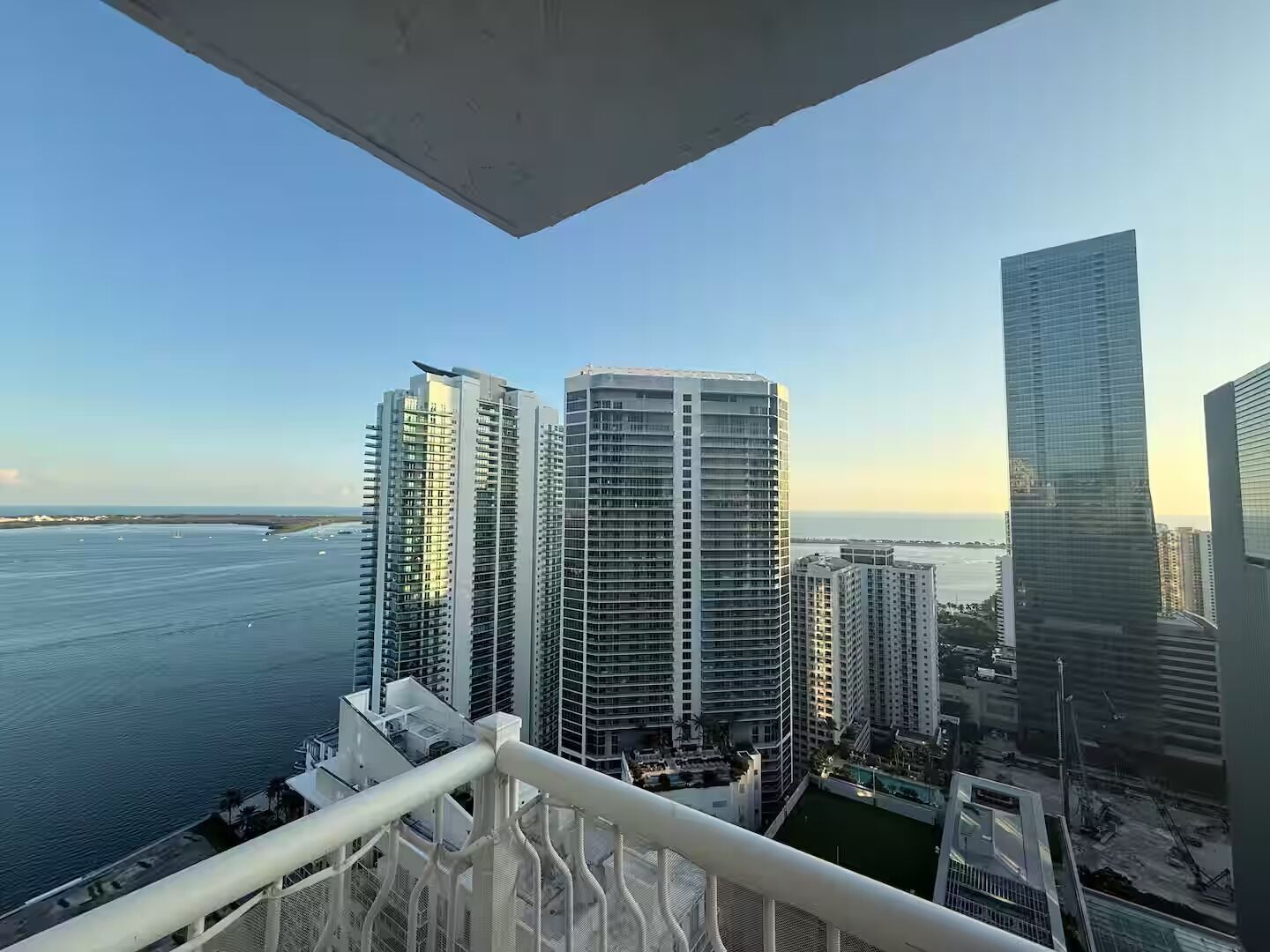 A high-rise building with a view of the ocean and other buildings.