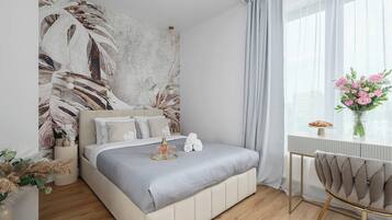Ein modernes Schlafzimmer mit Bett, Schreibtisch und einem Fenster mit Vorhängen.