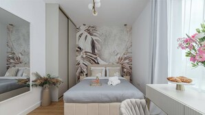 A bedroom with a bed, a bedside table, a chair, a mirror, and a window with curtains. - New House With Pool Near Beach (Warsaw)