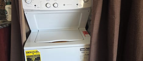 A front-loading washing machine with a control panel, ENERGYGUID sticker, and a label indicating ENERGY STAR certification.