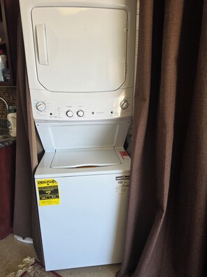 Una lavatrice a carica frontale con pannello di controllo, adesivo ENERGYGUID e etichetta che indica la certificazione ENERGY STAR.