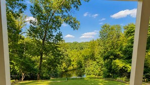 Un espace extérieur abrité offrant une vue sur un paysage verdoyant et des arbres.