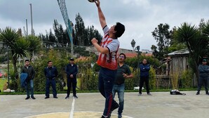 Una persona saltando para golpear un balón de fútbol en una cancha deportiva.