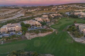 A residential area with houses, a golf course, and a desert landscape. - Luxury 4BR Villa | Pool, Jacuzzi & Golf Views (Cabo San Lucas)