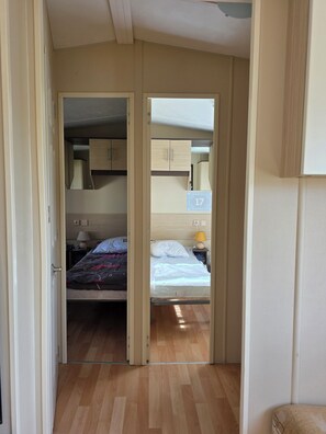 A room with a bed, a nightstand, a lamp, and a wardrobe. - 3-bedroom mobile home in pleasant Dolus-d'Oléron with AC and 4 x bikes (Dolus-d'Oléron)