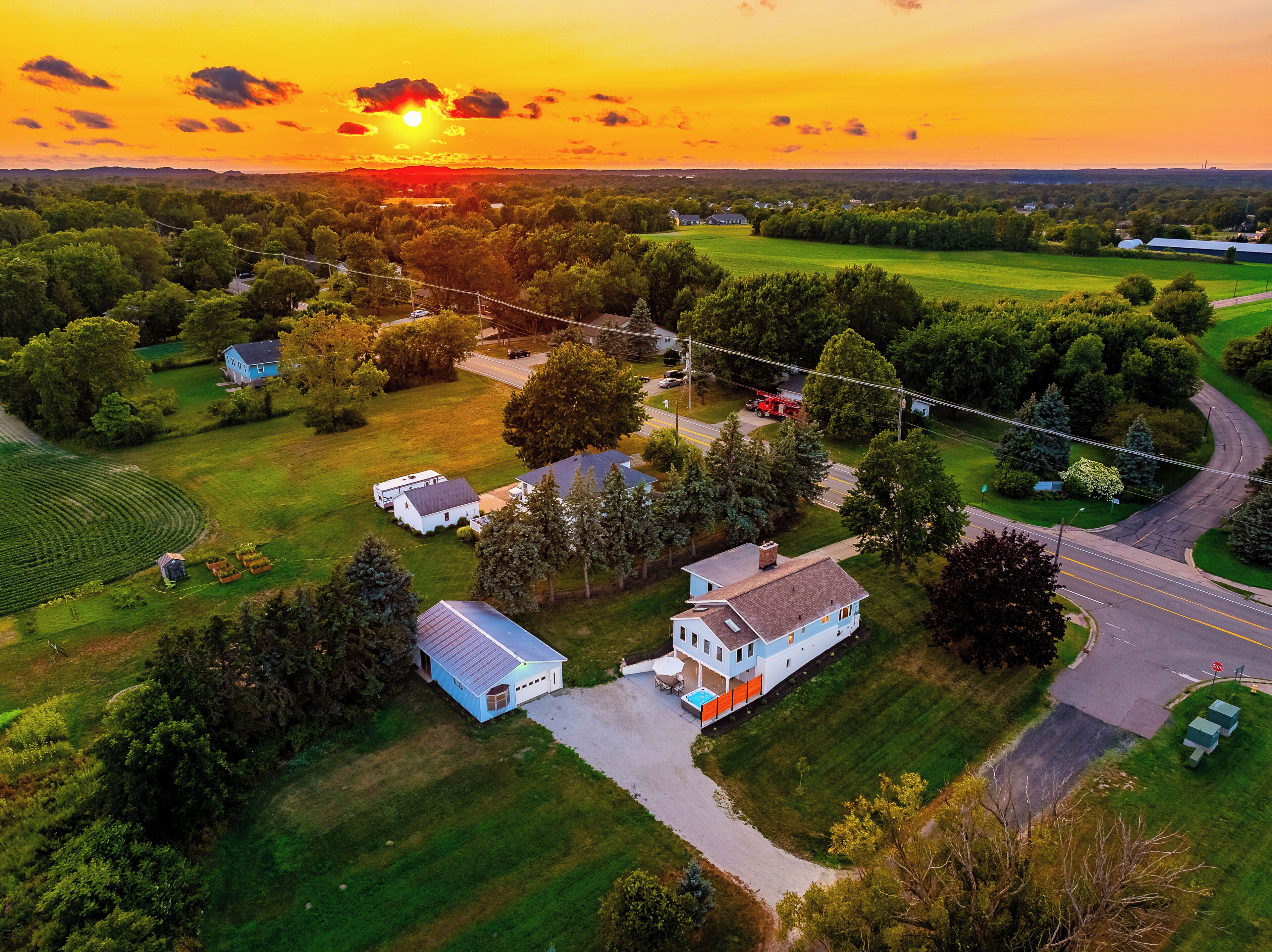 A residential area with houses, a road, and a sunset.