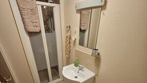 Een badkamer met toilet, wastafel en douche.