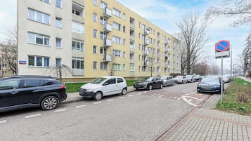 Ein mehrstöckiges Wohngebäude mit Parkplatz davor.