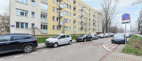 A multi-story residential building with a parking area in front.