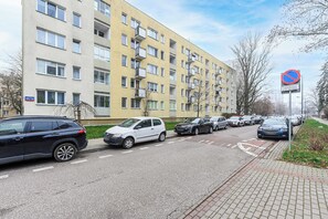 Un edificio residencial de varios pisos con un estacionamiento al frente.