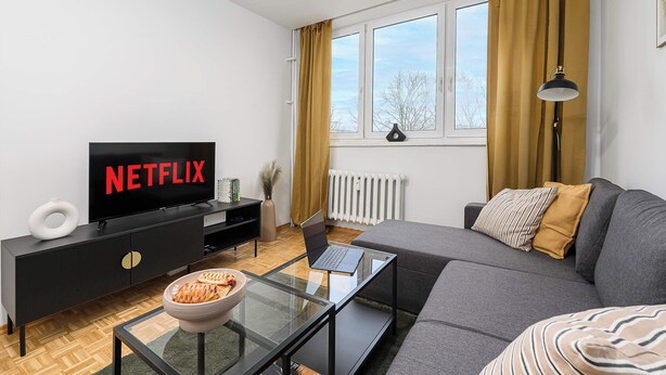 A modern living room with a flat-screen TV, a sofa, a coffee table, and a window with curtains. - Magnificent Beach House for 6 (Warsaw)