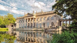 A classical building with a symmetrical facade, large windows, and a reflection in the water. - Magnificent Beach House for 6 (Warsaw)