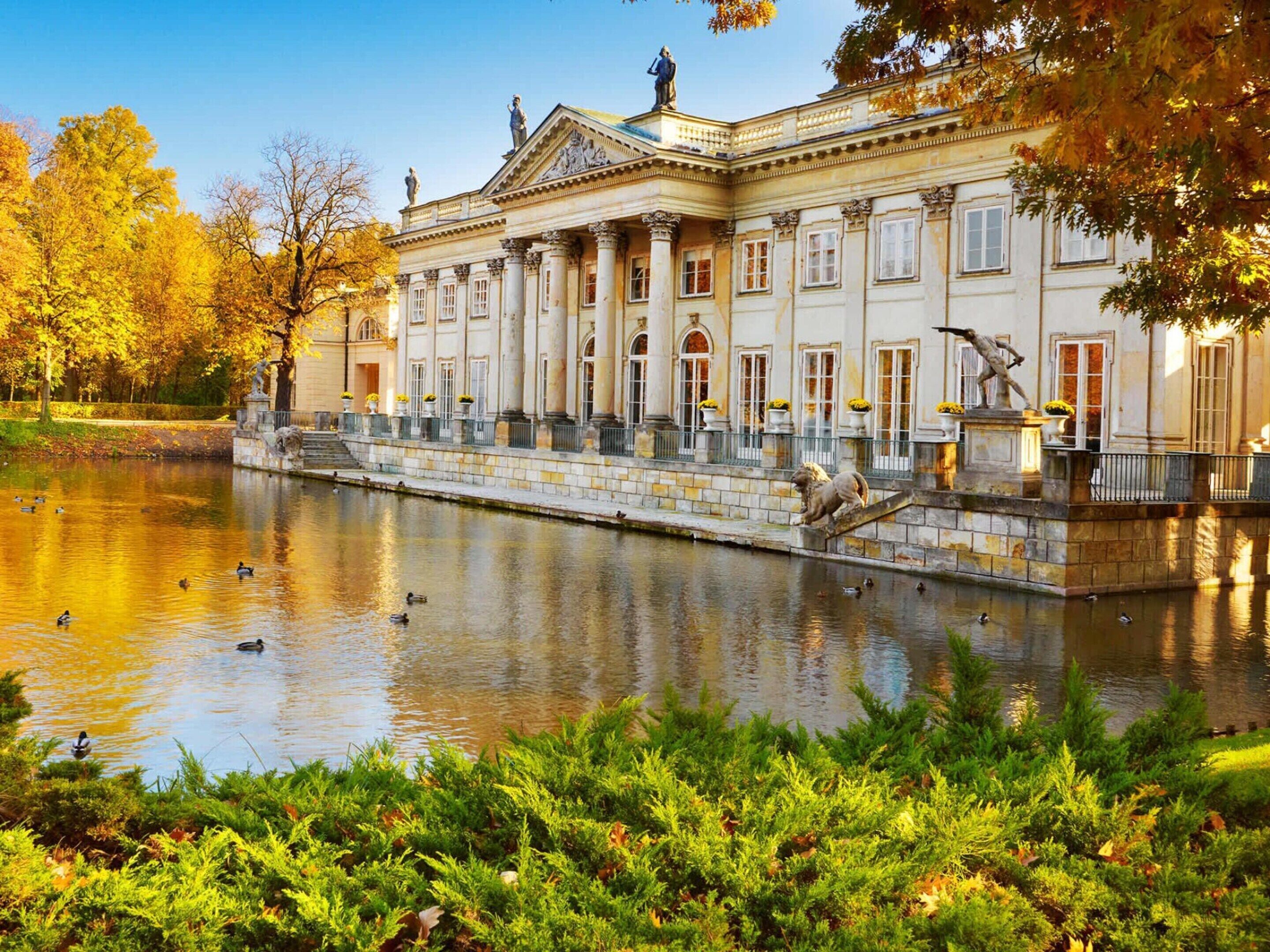 Ein klassizistisches Gebäude mit einer symmetrischen Fassade, einer zentralen Treppe und einem Wasserbecken davor.