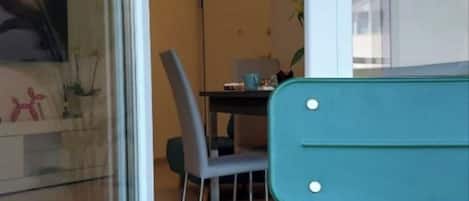 En matplats med ett bord och stolar, en glasvägg och utsikt över omgivningen.