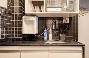 A kitchen with a coffee maker, a microwave, and a sink. - Modern Copacabana - Ipanema in the best location in Rio de Janeiro. (Rio de Janeiro)