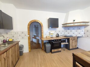 A compact kitchen with a wooden countertop, a built-in oven, and a sink.
