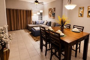 A dining area with a wooden table, chairs, and a vase of flowers. - CASA VERDE RESORT PROPERTY 20 MINS to DISNEY (Kissimmee)