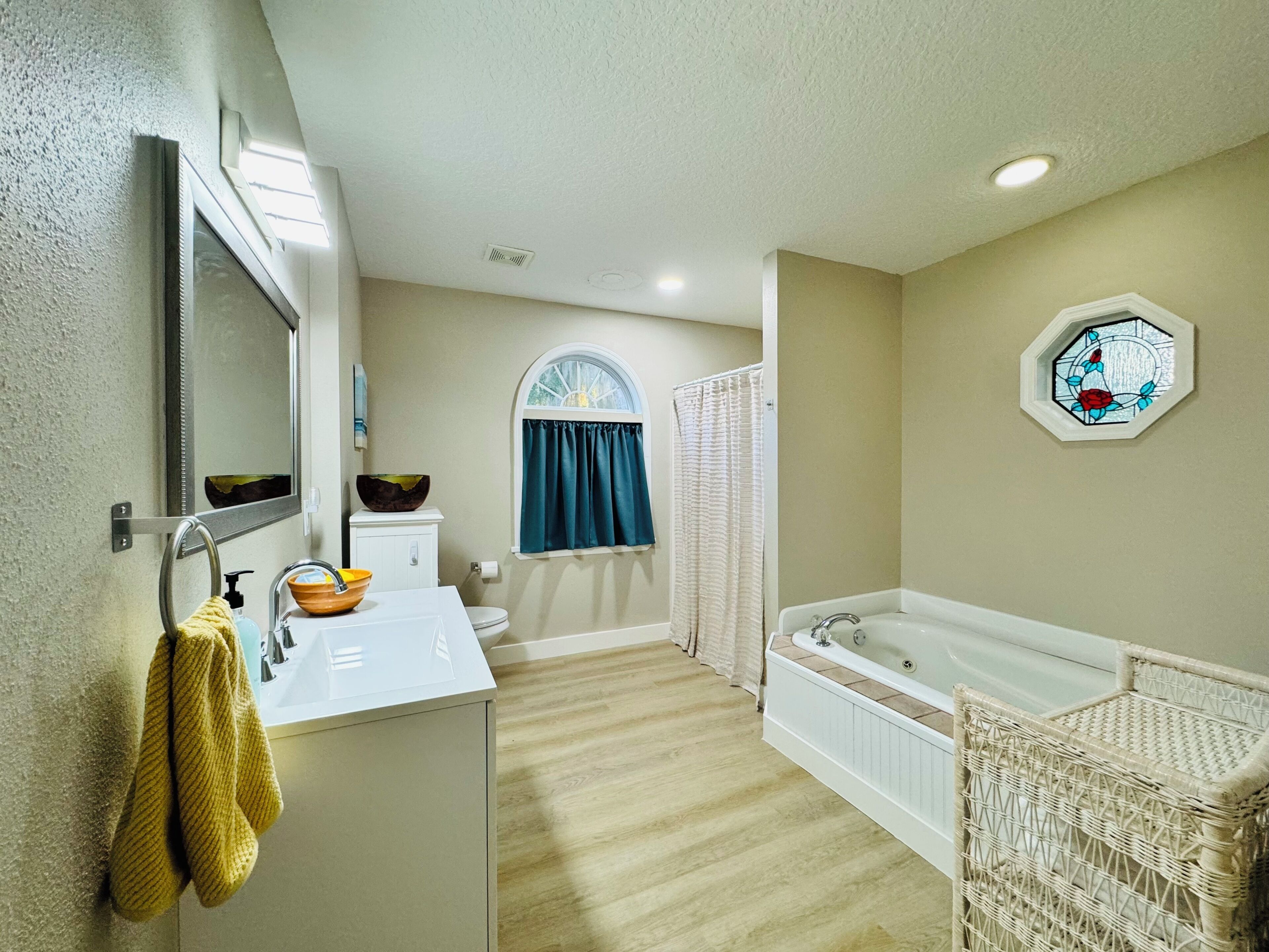 Une salle de bain avec un lavabo blanc, un miroir et une baignoire.