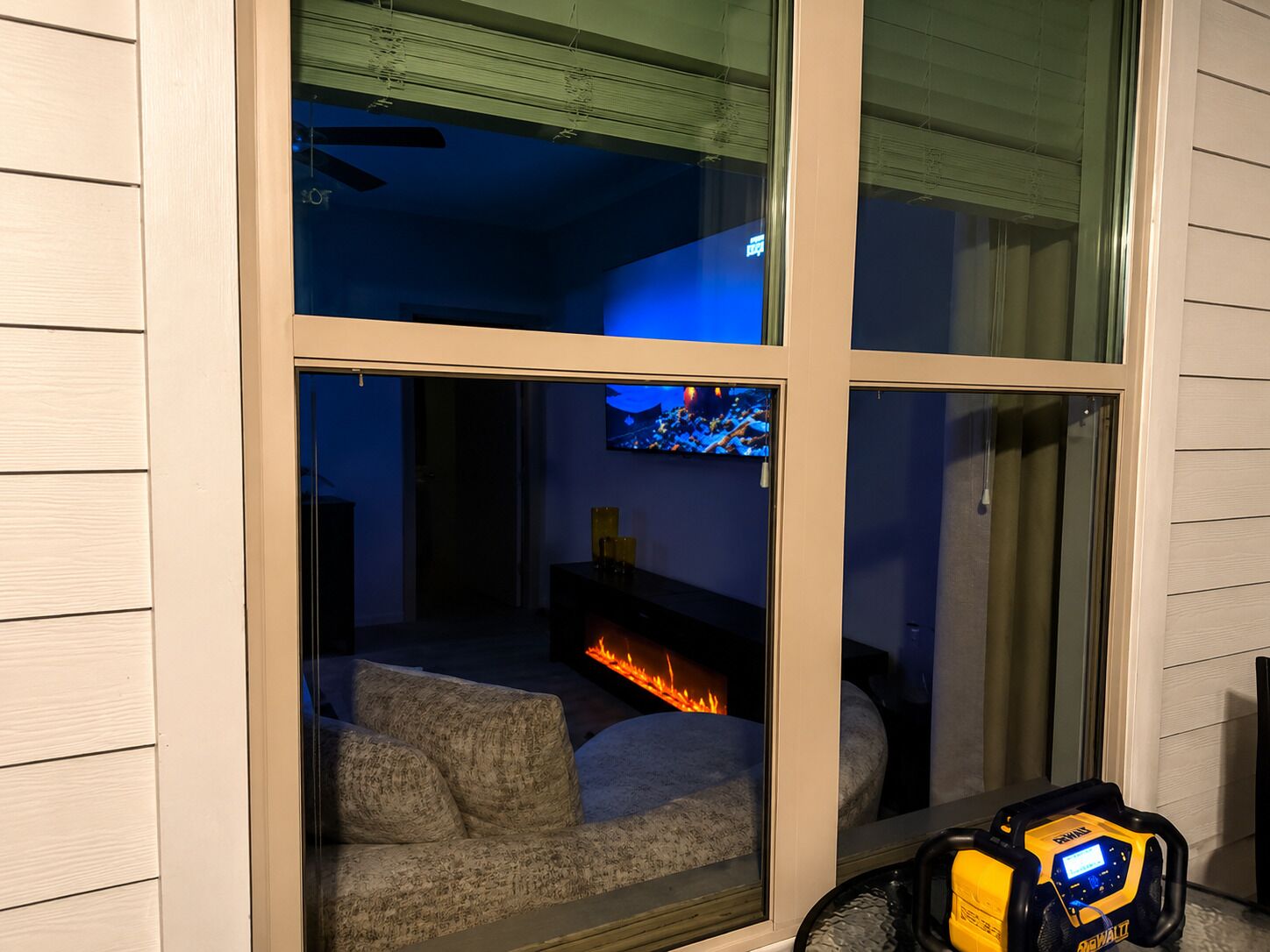 A room with a fireplace, a sofa, and a window with blinds.