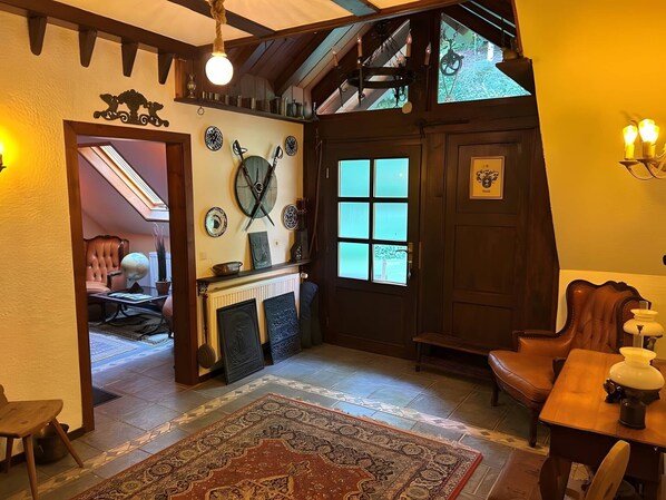 A traditional interior with a fireplace, a wooden door, and a dining area.