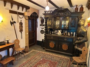 A room with a wooden cabinet, a rug, and a chair.