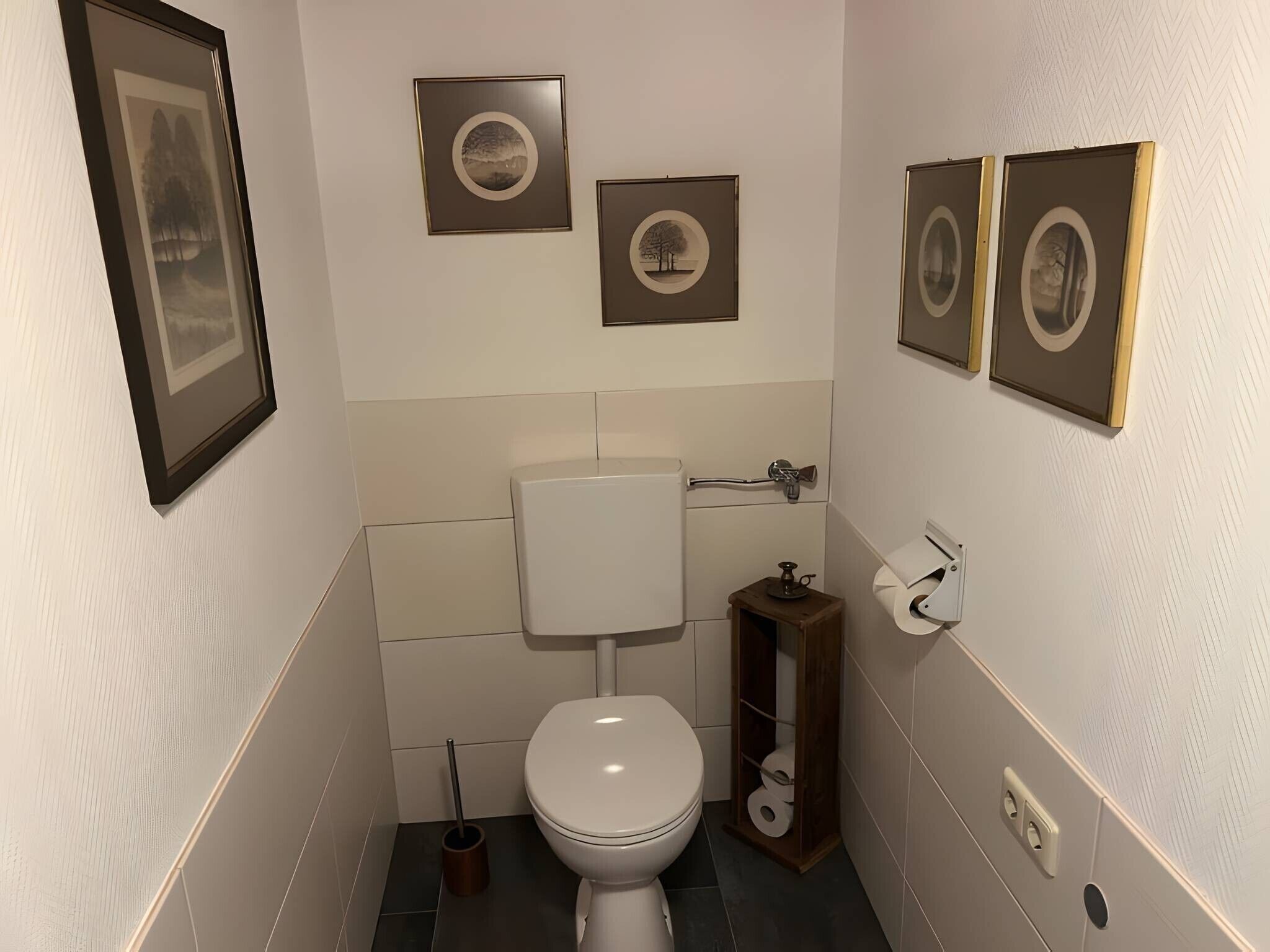 Ein kleines, modernes Badezimmer mit Toilette, Bidet und Toilettenpapierhalter.