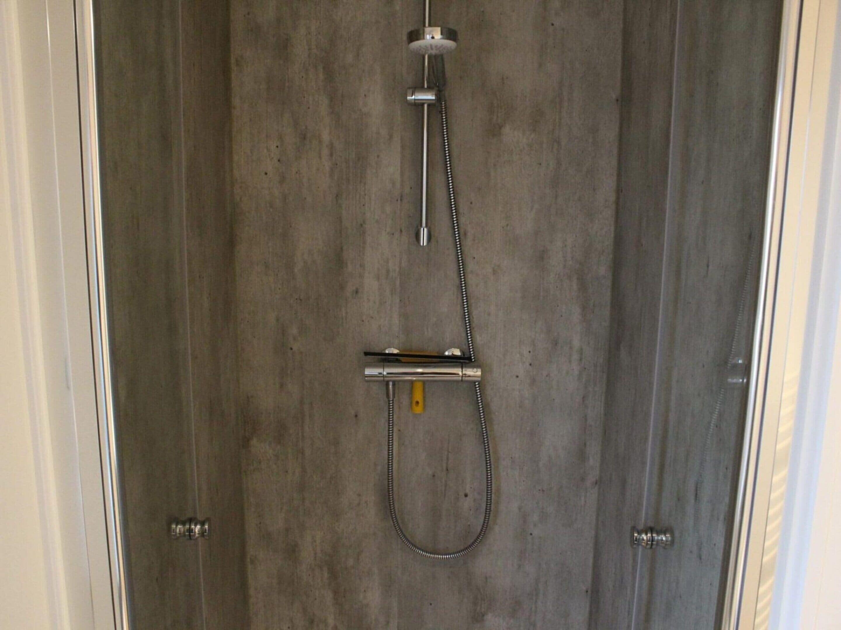 Eine Dusche mit Duschkopf und Handbrause.