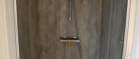 Eine Dusche mit Duschkopf und Handbrause.