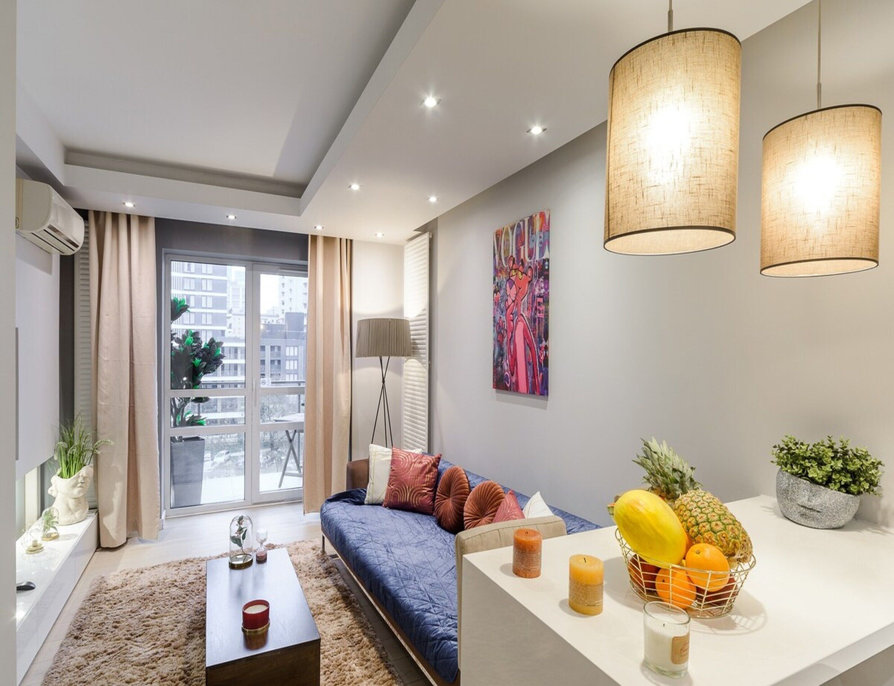 Una sala de estar moderna con un sofá, una mesa de centro y una cesta de fruta.