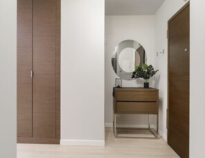 A room with a wardrobe, a mirror, a plant, and a cabinet. - City Apartment With Balcony (Warsaw)