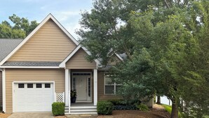 A single-story house with a garage, a front porch, and a driveway. - Spacious 4-bedroom, waterfront townhome at Lake Gaston (Henrico)