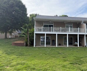 A two-story house with a covered porch and a large tree in the yard. - Spacious 4-bedroom, waterfront townhome at Lake Gaston (Henrico)