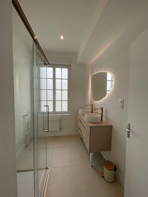 A modern bathroom with a glass shower enclosure, a double sink vanity, and a large mirror. - Elegance & Light in the Heart of Brest (3 bedrooms/6 guests) (Brest)