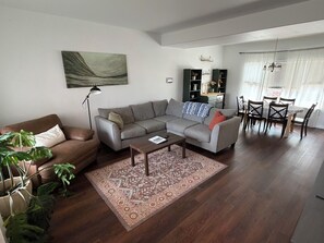 Un salon comprenant un canapé, une table basse et un coin repas avec des chaises et une table.