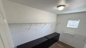 Ein Zimmer mit schwarzem Stauraum, einer Deckenleuchte, einem Fenster und einer Heizung.
