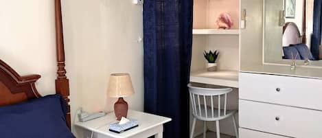 Un dormitorio con cama, mesita de noche, lámpara, silla, cómoda y espejo.