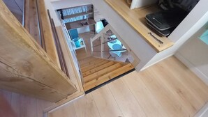 Eine Holztreppe führt zu einem Essbereich mit Tisch und Stühlen.