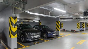 Ett parkeringsgarage med två bilar parkerade på anvisade platser, markerade med gula linjer och nummer.