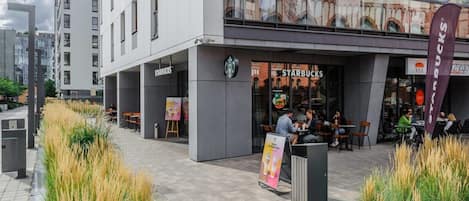 A modern building with a Starbucks café on the ground floor.