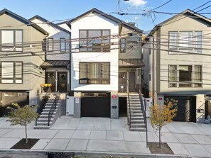 A residential building with a garage, a staircase, and a small tree in the front yard. - The Cozy Corner / Newark safe urban cozy stay (Newark)