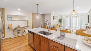 Una cocina moderna con una isla central, lavavajillas integrado y un comedor con mesa redonda.