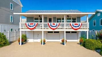 A two-story house with a balcony, white railings, and a garage.