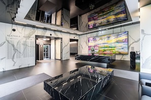 A modern lobby with a marble floor, a glass coffee table, and a large abstract painting. - Warsaw Flat With Balcony (Warsaw)